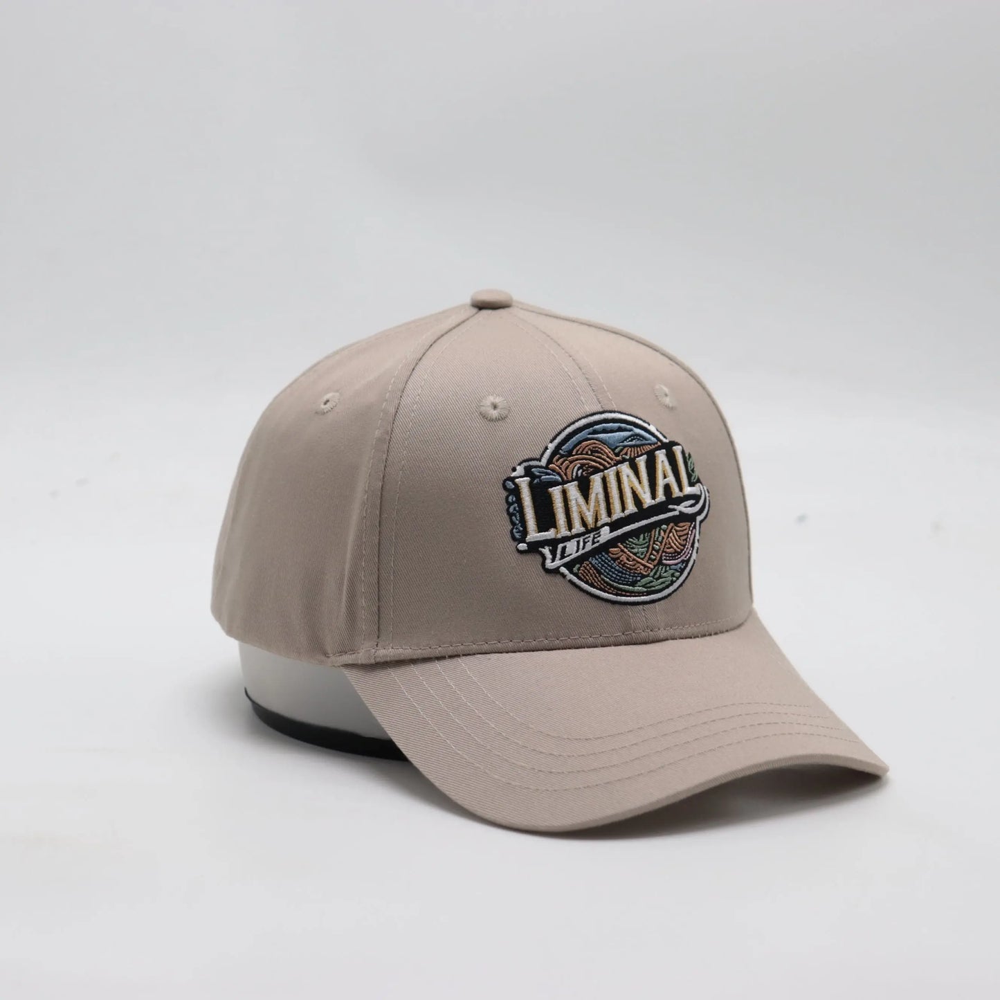 Slightly turned to the side view Front view of The TideTurner hat in ivory color made of 65% recycled ocean bound plastic featuring Liminal Life's embroidered logo.